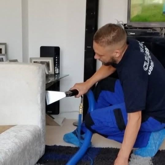 Cleanways technician cleaning a sofa and rug in a client's home